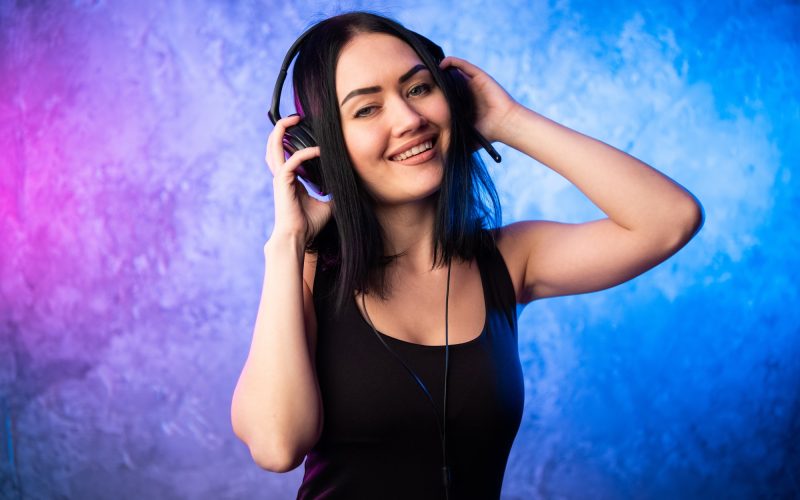 colorful-portrait-in-blue-and-pink-ligth-of-a-young-dj-woman-wearing-headset-and-enjoying-an.jpg